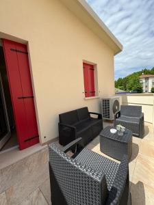 a patio with couches and tables and red doors at Casa Laguna Escape in Mestre
