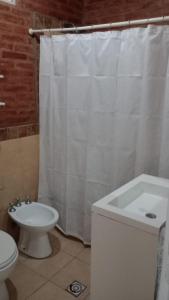 a bathroom with a white shower curtain and a toilet at Casa Finca in Santiago del Estero