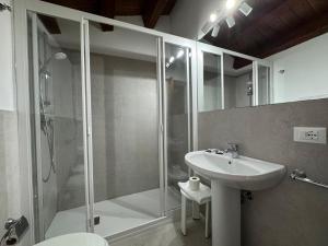 a bathroom with a glass shower and a sink at Case Ruggero in Cefalù