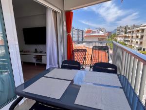 een tafel en stoelen op een balkon met een televisie bij SATORI Romantyczny azyl dla dwojga 150 m od plaży - apartament z balkonem i parkingiem, Playa de Gandia in Playa de Gandia