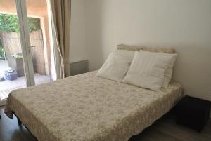 サントロペにあるLes rives de St Tropezのベッドルーム1室(枕2つ、窓付)