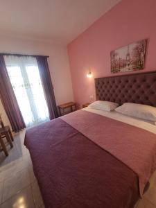 a bedroom with a large bed and a large window at Sun Ray Sivota 7 in Syvota