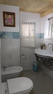a bathroom with a white toilet and a sink at Le Mennule 26 in Alliste +25 photos