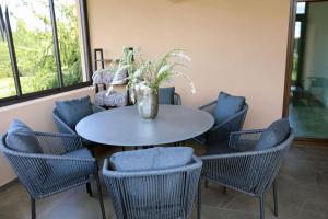 a table with chairs and a vase with a plant on it at Lauras Apartment in Bauska