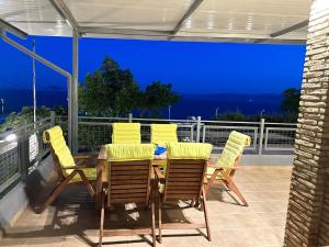 a patio with a table and chairs on a balcony at Magic View 4U Luxury Villa, Tago Vibes in Kineta