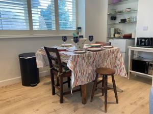 a kitchen with a table with chairs and a table cloth at The Garden House in Dewlish