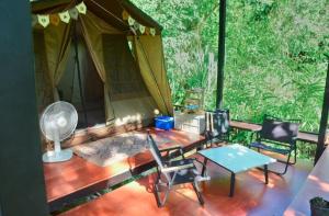 a room with a tent and a table and chairs at Pingjai Halal Camping in Ban Nong Mai Kaen