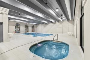a swimming pool with two jacuzzis in a building at Clarion Inn Branson in Branson