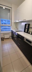a kitchen with black and white counters and a window at Mimoza in Novi Beograd +8 photos