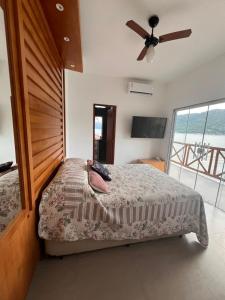 a bedroom with a bed and a ceiling fan at Casa AMar Mangaratiba in Mangaratiba +14 photos