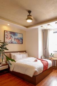 a bedroom with a bed and a painting on the wall at Tasme Hotel in Da Lat