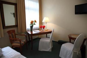 una habitación de hotel con una mesa con flores. en Hotel Laacher Lay, en Mendig