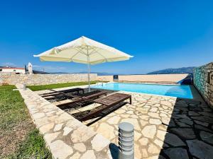 a patio with an umbrella and a swimming pool at Villa Onar Nafpaktos with private pool in Nafpaktos