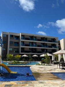 a hotel with a swimming pool with a slide at Flat em Muro Alto - Porto de Galinhas - Malia Beach in Ipojuca