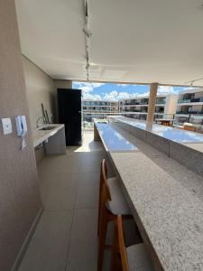 a bathroom with a long counter with a view of a building at Flat em Muro Alto - Porto de Galinhas - Malia Beach in Ipojuca +57 photos