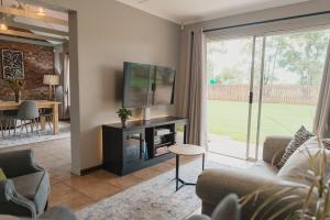 a living room with a tv and a couch and a table at Welverdiend - Unit 2 in Bloemfontein