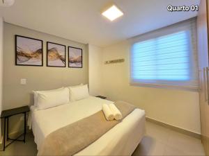 a bedroom with a white bed and a window at Novo Centro 2 quartos 2 banheiros e churrasqueira in Foz do Iguaçu