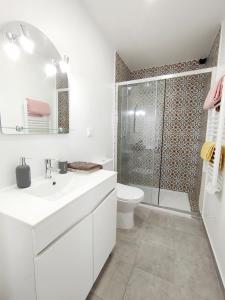 a white bathroom with a shower and a toilet at Cosy Home Santana in Santana