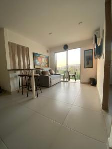 a living room with a couch and a table at Apartamento Vacacional con Piscina WiFi y Netflix a 20 min del Parque Tayrona ideal para trabajo remoto in Santa Marta +14 photos