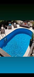 a blue swimming pool with chairs and a patio at Luxury Apartments with Private Pool and Sauna or with jacuzzi near Split , Sea View in Podstrana