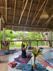 a group of people sitting on the floor doing yoga at Mangrove Lodge in Zanzibar City