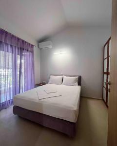 ein Schlafzimmer mit einem großen weißen Bett mit einem Fenster in der Unterkunft Casa di Palma Beach Front in Pefkohori + 14 Fotos