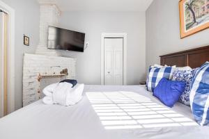 ein Schlafzimmer mit einem weißen Bett mit Handtüchern darauf in der Unterkunft HISTORIC DOWNTOWN KING BED COTTAGE- PARKING and PATIO in Savannah