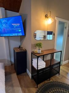 Zimmer mit einem TV und einem Tisch mit Handtüchern. in der Unterkunft פרא בקתות אירוח in Nir Yafe