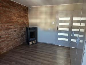 a room with a television and a brick wall at Loft&Cozy in Zgorzelec