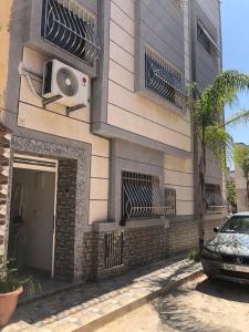 ein Gebäude mit einem davor geparkten Auto in der Unterkunft Appartement cosy 1er étage in Kenitra