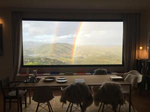 a rainbow is seen through a large window at Casa Vesta in Zufre +62 photos