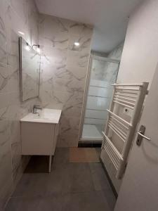 a bathroom with a sink and a shower with a mirror at Spacious house - garden, Netflix & shops in Béguey +14 photos