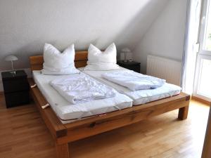 two beds with white sheets and pillows on them at Ferienwohnungen im Veenhuus - Tierfreundlich in Kellenhusen