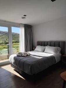 a bedroom with a large bed with a large window at Pie de Piedra Hotel Boutique in Sierra de la Ventana +47 photos