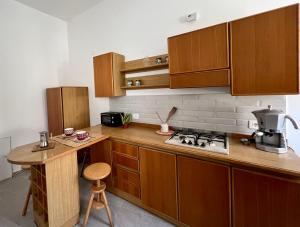 a kitchen with wooden cabinets and a counter top at La casa dell'Artemisia in Cefalù