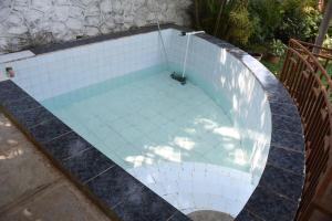 an overhead view of a swimming pool with white tiles at Bapunchi Wadi, beach-house in Alibaug