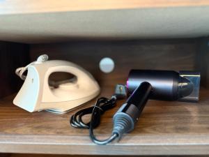 a flashlight and a hair dryer on a shelf at Almas Suites, Puteri Harbour SI home in Iskandar Puteri