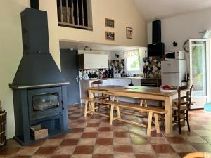 a kitchen with a wooden table and a stove at La petite vallée in Crozant