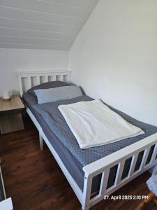 a bed in a room with a white bed frame at Zur langen Heide in Hildburghausen