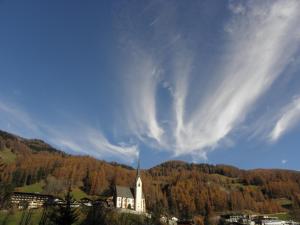 a church with a steeple in front of a mountain at Nationalpark-Camping Großglockner in Heiligenblut