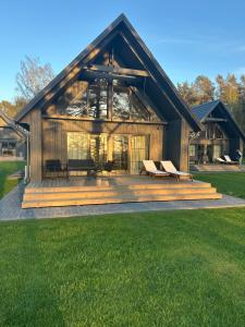 a large wooden house with a deck with benches at Storm Villas in Sturmai