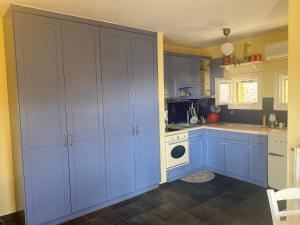 une cuisine avec des armoires bleues et une cuisinière blanche dans l'établissement ΚΑΛΛΙΣΤΗ HOUSE, à Posidhonía