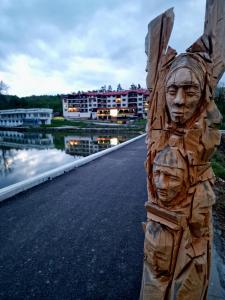 a wooden sculpture of faces on the side of a road at Rebeka Luxury Apartment in Tryavna