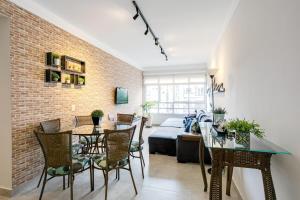 圣保罗Apartamento grande, espaçoso - Mackenzie, Higienópolis的用餐室和带砖墙的客厅