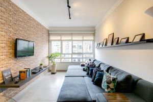 圣保罗Apartamento grande, espaçoso - Mackenzie, Higienópolis的带沙发和砖墙的客厅