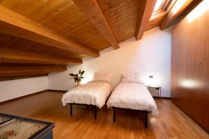 two beds in a room with wooden ceilings at Dimore Al Borgo in Montagnana