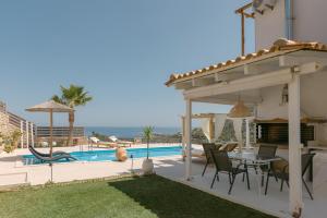 a patio with a table and chairs next to a pool at Villa Aldea Bali - Sea View - Private Pool in Vlikhádha