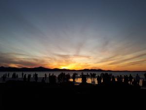 een groep mensen die bij zonsondergang op het strand staan bij Apartment Aldora in Zadar