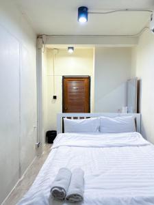 a white bed with two pairs of slippers on it at Chubbi5 room11 in Bangkok +9 photos