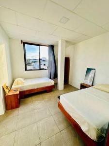 a large room with two beds and a window at Family-friendly with balcony and terrace in Puerto Ayora +2 photos